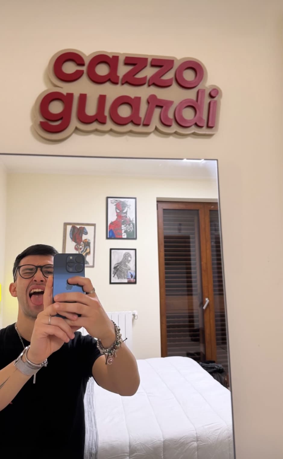 Guy taking a mirror selfie under the “cazzo guardi” sign