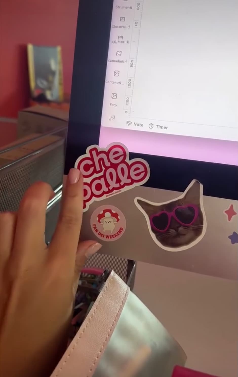 Stickers, including “che palle” and a cat with heart-shaped glasses, stuck under a screen