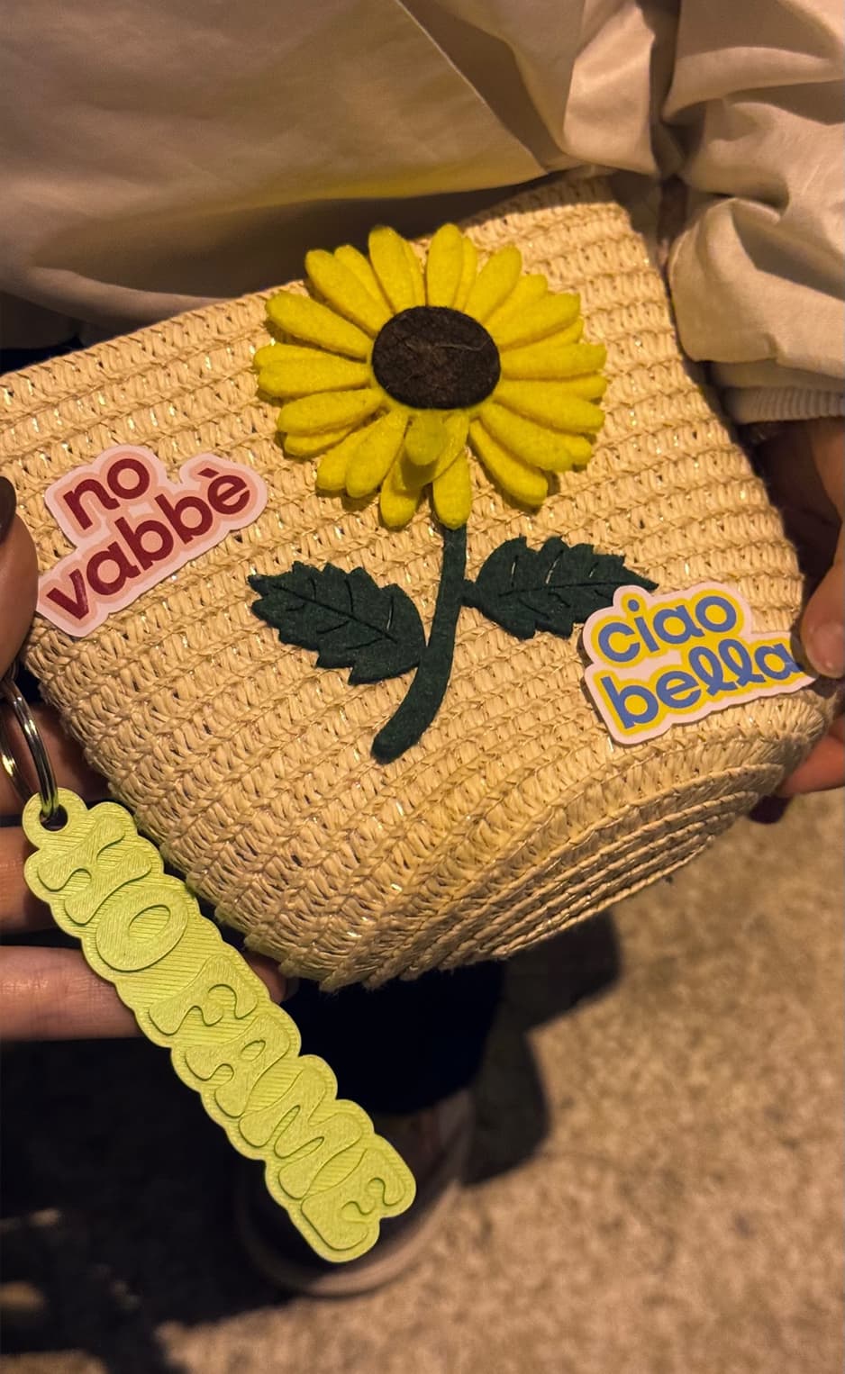 Straw bag decorated with stickers and a yellow Notami keychain