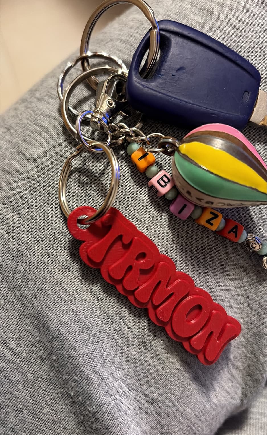Red Notami keychain beside a keychain with colourful beads